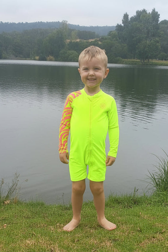 Child wearing bright Yellow Sea Me Swimwear Zebra Swimsuit at the lake.