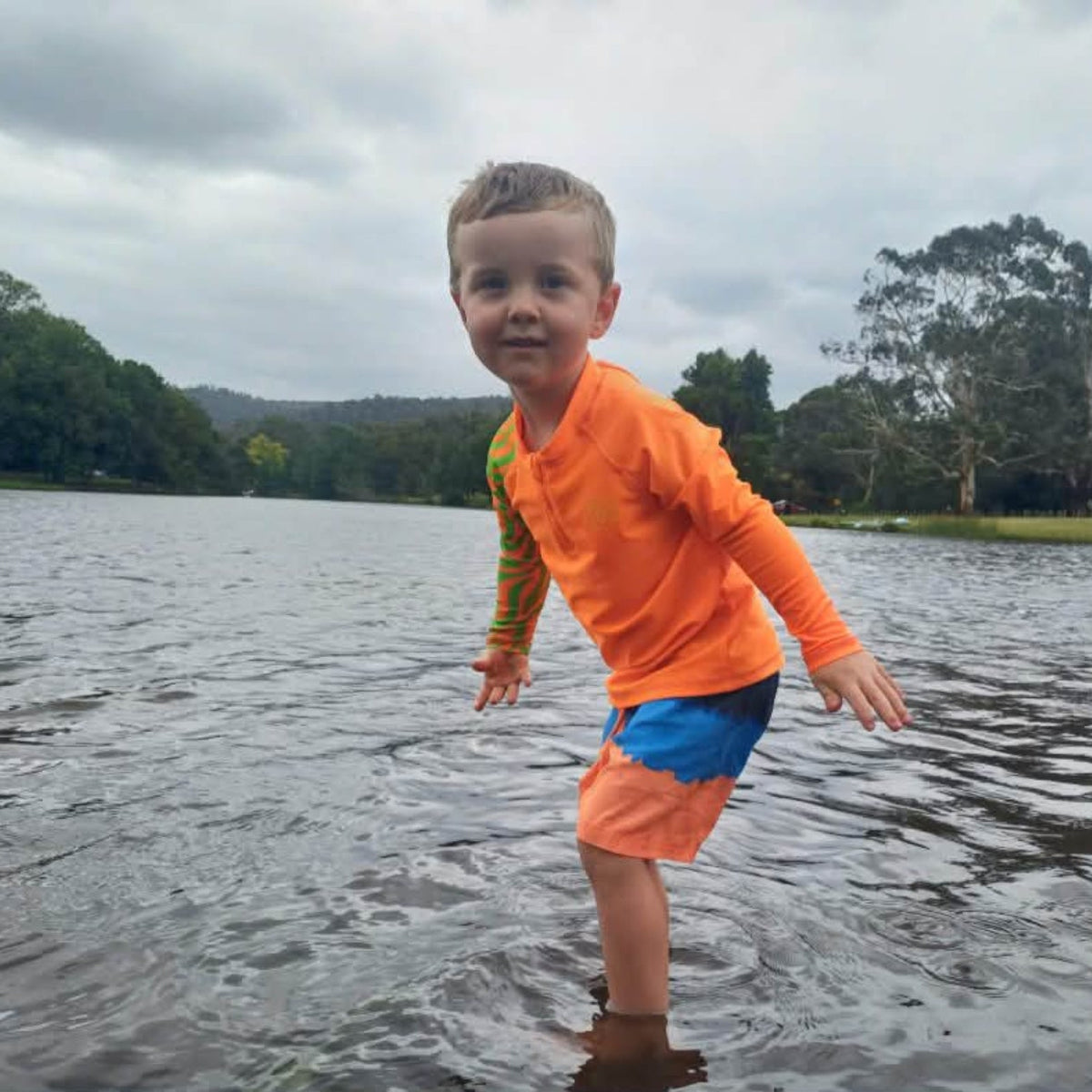 Child wearing bright Orange Sea Me Swimwear Zebra Rash Top
at the Lake.